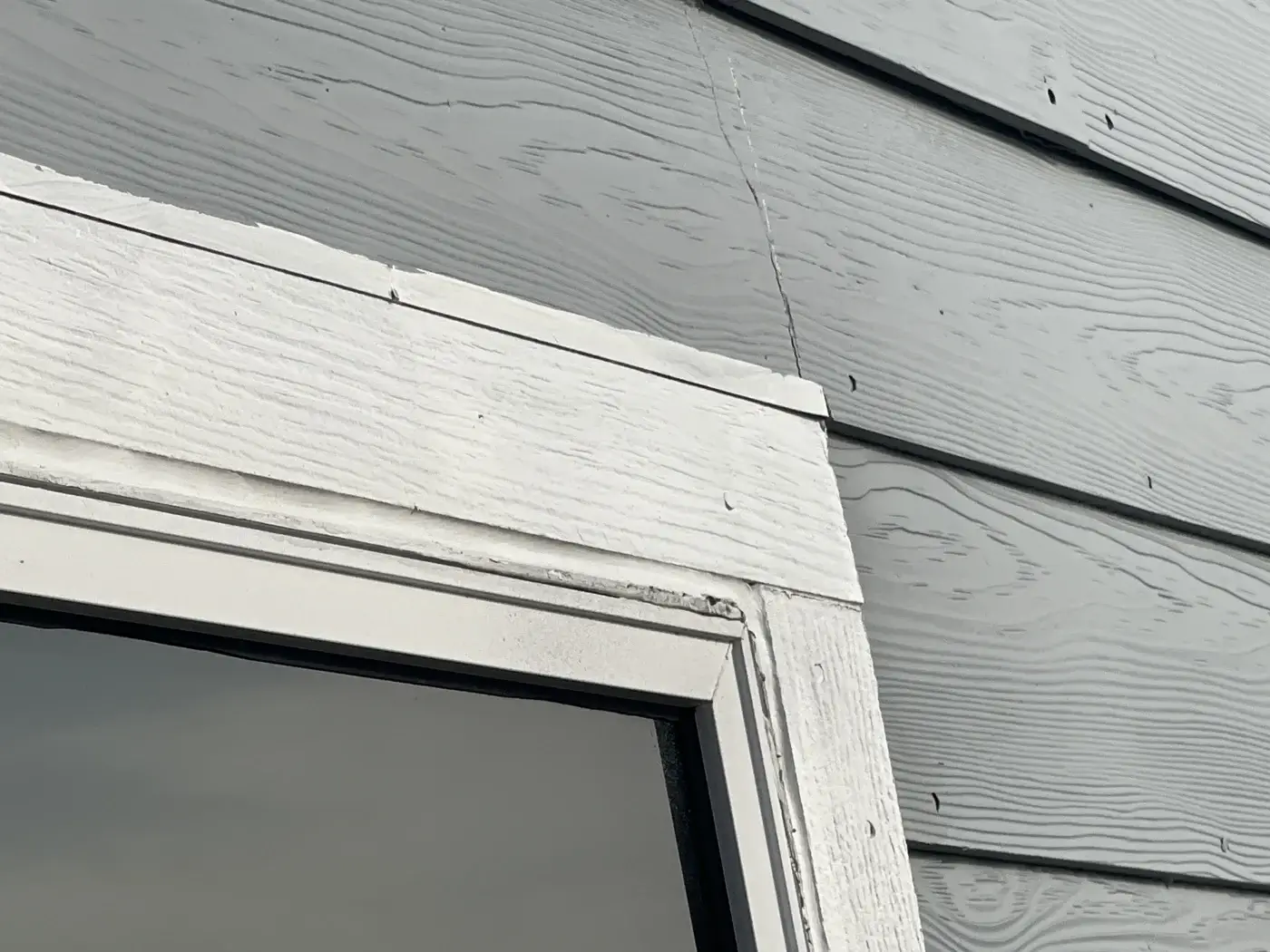 Close-up of window trim and siding during a property claim inspection