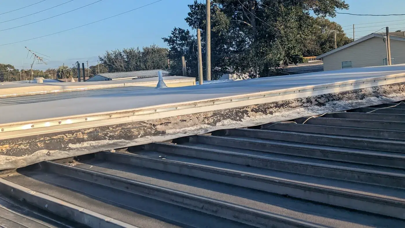 Damaged roof deck edge exposed during inspection