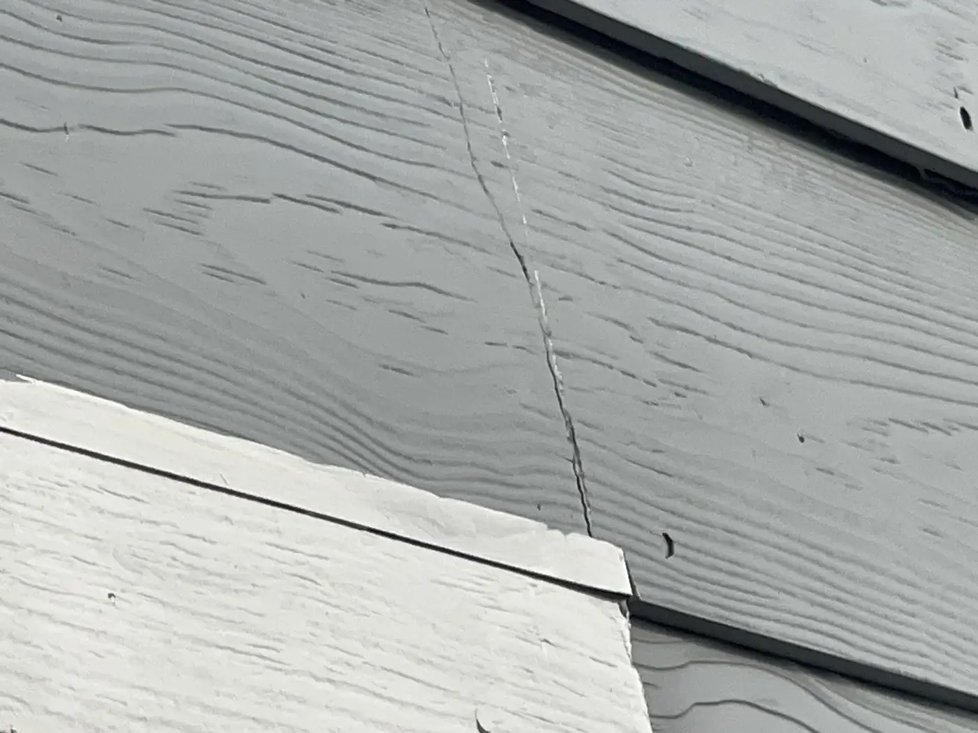 Close-up of a siding crack documented during a property claim inspection